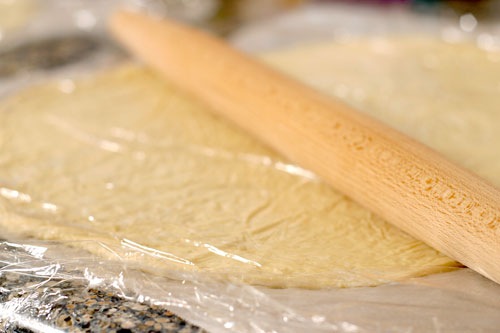 Rolling thin crust pizza dough out, using parchment paper