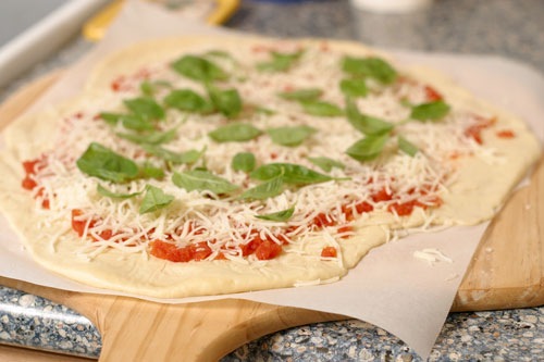 A basil thin crust pizza ready to be baked